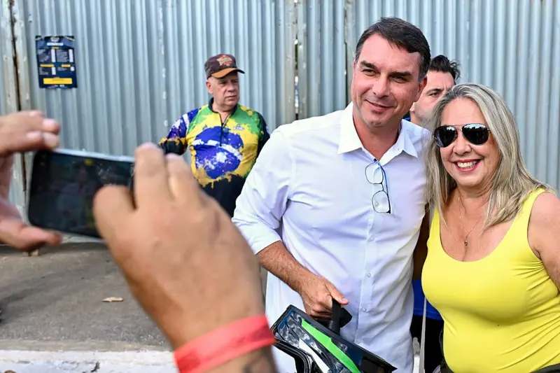 Flavio Bolsonaro tomándose una foto con una seguidora del expresidente