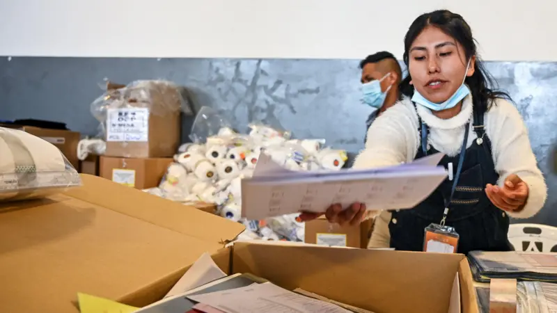 Una empleada electoral prepara una urna y materiales antes de las elecciones generales que se celebrarán el 17 de agosto en La Paz, Bolivia