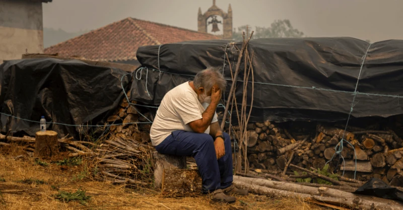Un hombre sentado con la mano en la cabeza se lamenta por la trágica situación por la que está pasando