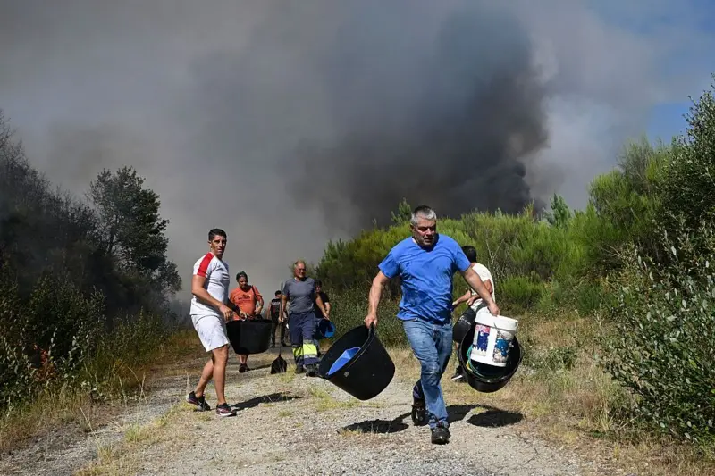 Vecinos con baldes de agua para combatir los incendios