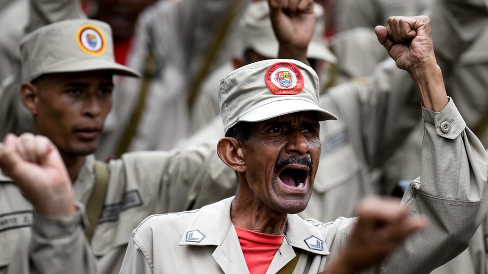Miembros de La Milicia venezolana alzando los puños