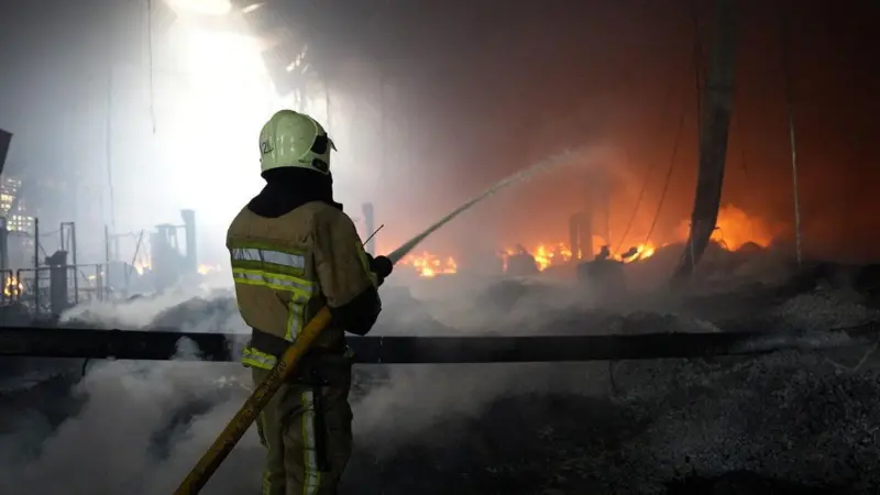 Un bombero ucraniano intentando apagar un incendio en una fábrica en la región de Zakarpatia