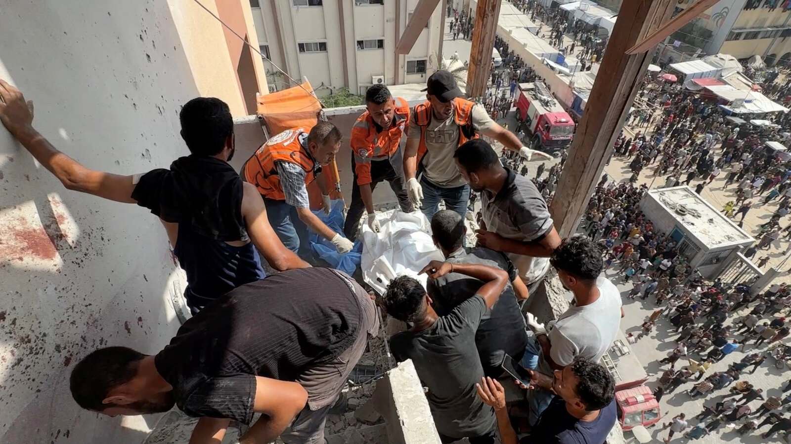 Miembros de equipos de rescate y otras personas se aglomeran en una terraza del hospital Nasser en Gaza